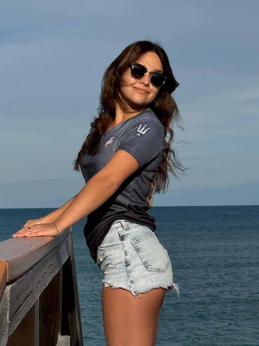 Short sleeve performance V neck. Front & side with King Tide logo on left chest and tridents on sleeves. in Serene Black. XS-4X. Made in USA