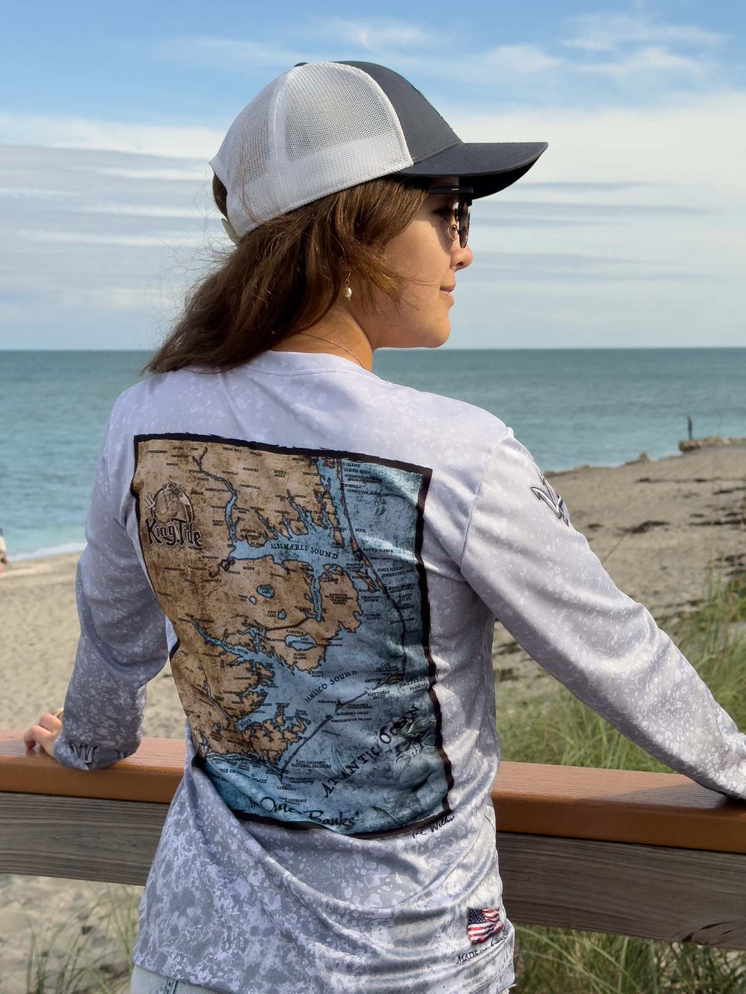 King Tide long sleeve performance shirt with slate fossil allover print. Back featuring vintage style map of Outer Banks. Trident on sleeve at shoulder.  XS-2X. UPF 50. made in USA. Original art by Tal Willis