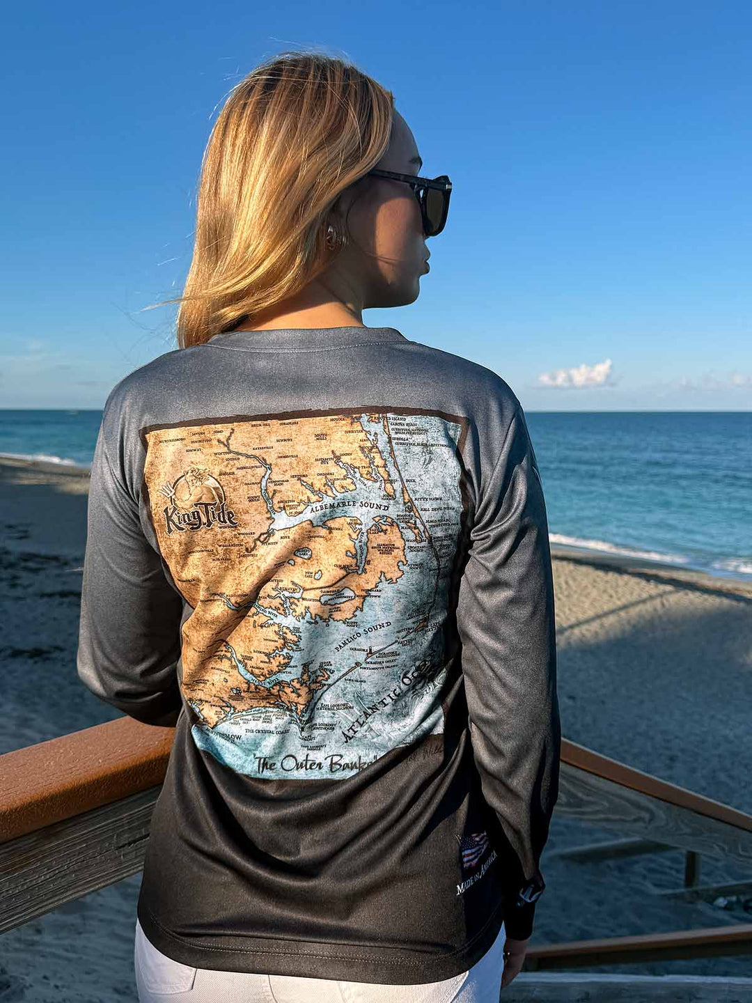 King Tide ladies long sleeve performance shirt in serene black.  Back side features vintage style map of The Outer Banks. UPF50 XS-2X.Made in USA. Original artwork and design by Tal Willis.