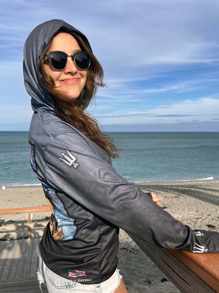 King Tide performance hoodie in serene black.  Showing right side.  Double lined hood. 3D trident on sleeve at shoulder and wrist. XS-4X.  American flag 'Made in America' bottom right, back side. Original art and design by Tal Willis