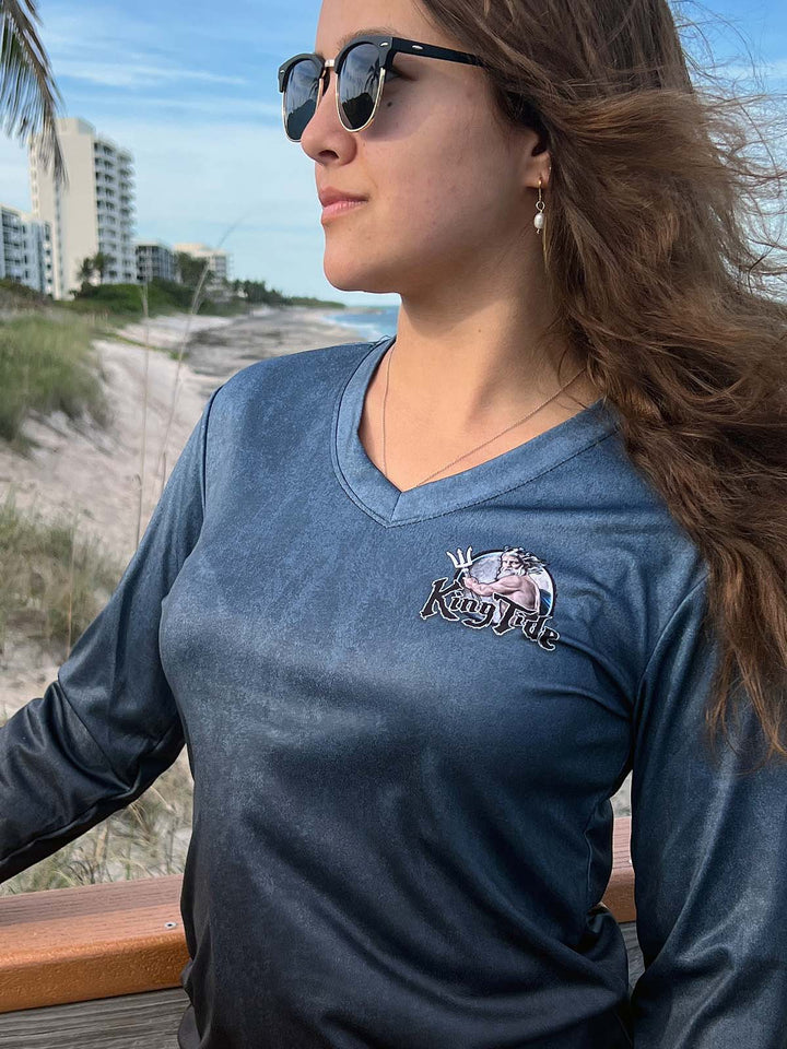 Serene Black, long sleeve  performance shirt. Front side showing V neck detail and King Tide logo on left chest. UPF 50. XS-2X. Made in USA. Original art and design by Tal Willis.