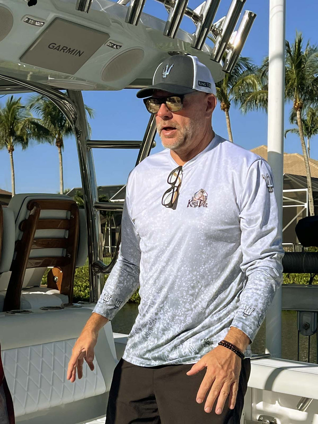 Long sleeve performance shirt with slate fossil, allover print.  Front side showing King Tide logo on left chest, tridents on sleeves at shoulders and wrists. UPF 50. XS-5X. Made in USA. Original art and design by Tal Willis.