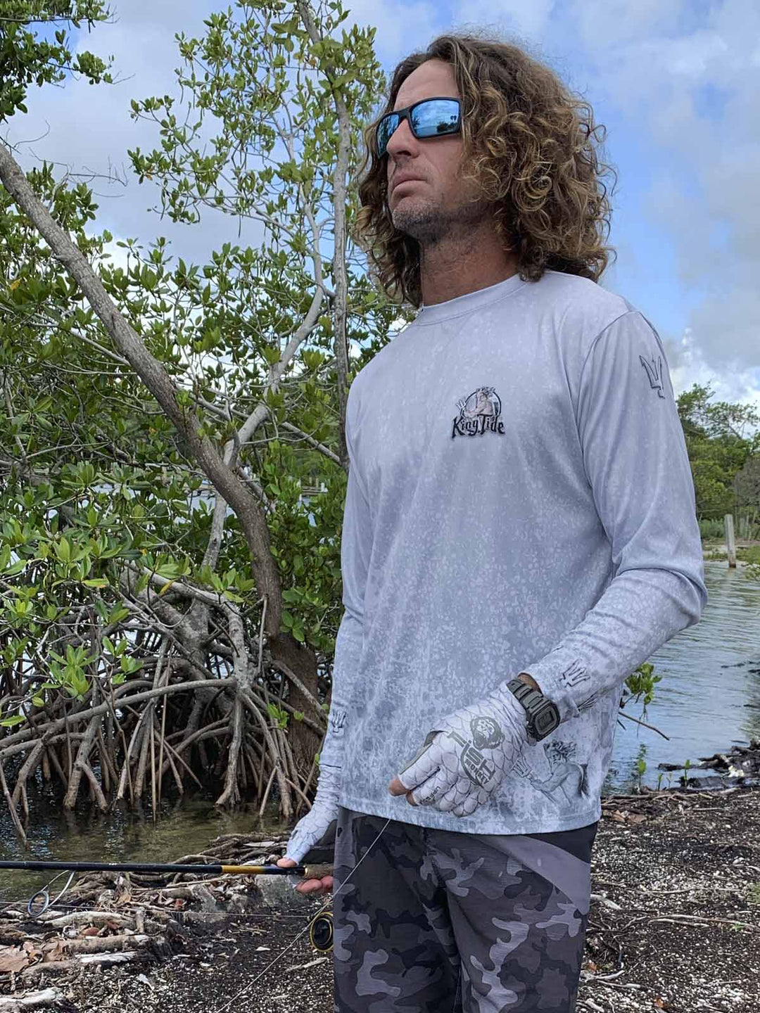 Long sleeve performance shirt with slate fossil, allover print.  Front side showing King Tide logo on left chest, tridents on sleeves at shoulders and wrists. UPF 50. XS-5X. Made in USA. Original art and design by Tal Willis.