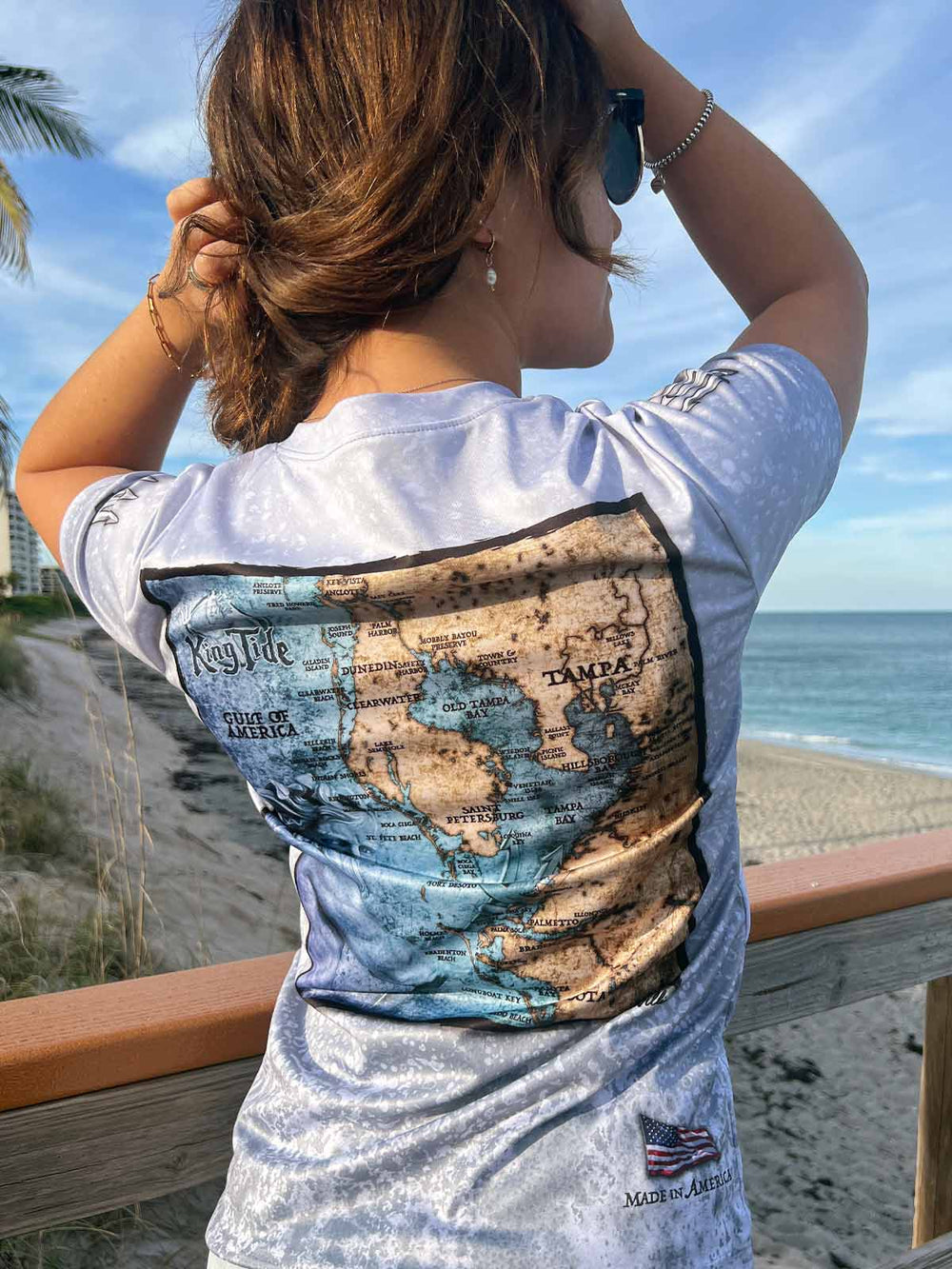 Slate fossil print on a short sleeve performance shirt featuring a vintage style map of Tampa, FL. Tridents on sleeves. American flag 'Made in America' on bottom right. XS-4X. 